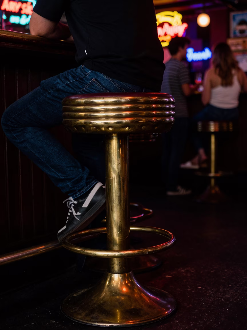 1980s San Diego Nightlife Scene with Polished Brass Stool Leg and Casual Bar Interior in in San Diego, California, United States