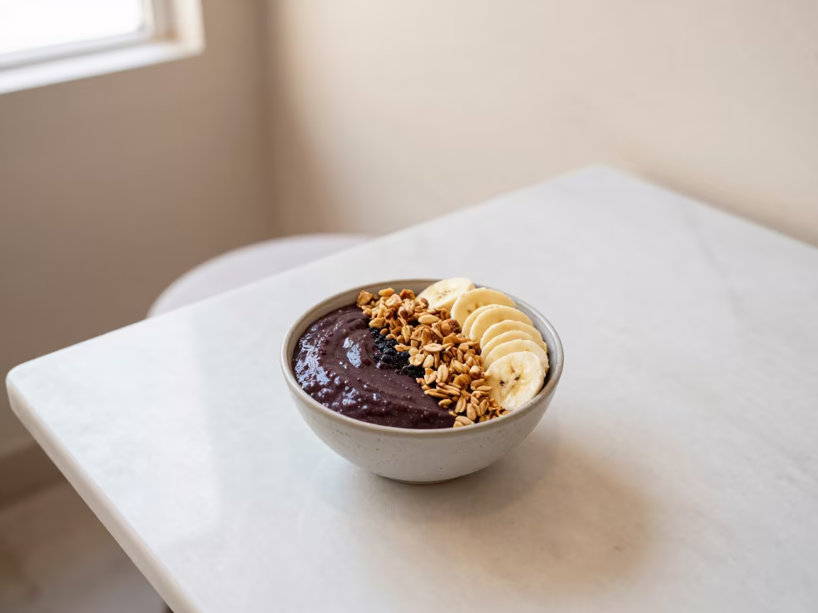 Acai Bowl with Granola and Banana on Marble Table in on a marble cafe table in Puebla