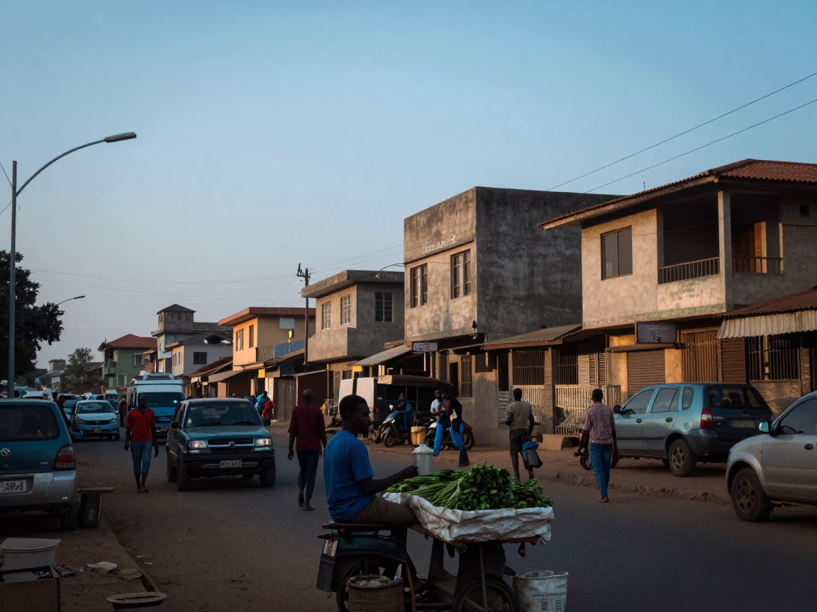 Accra Ghana street scene at dawn with vendor selling fresh produce near urban buildings in in Accra, Ghana