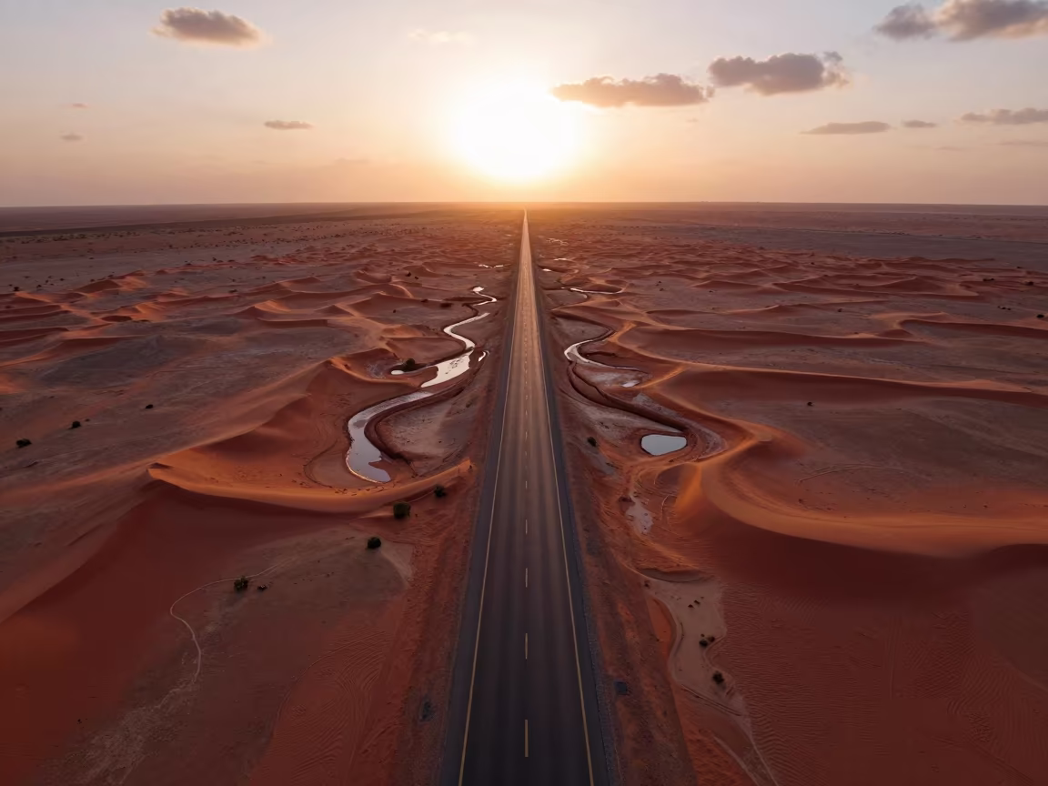 Aerial Desert Highway Vanishing Into Red Dunes in high above braided river channels in Egypt