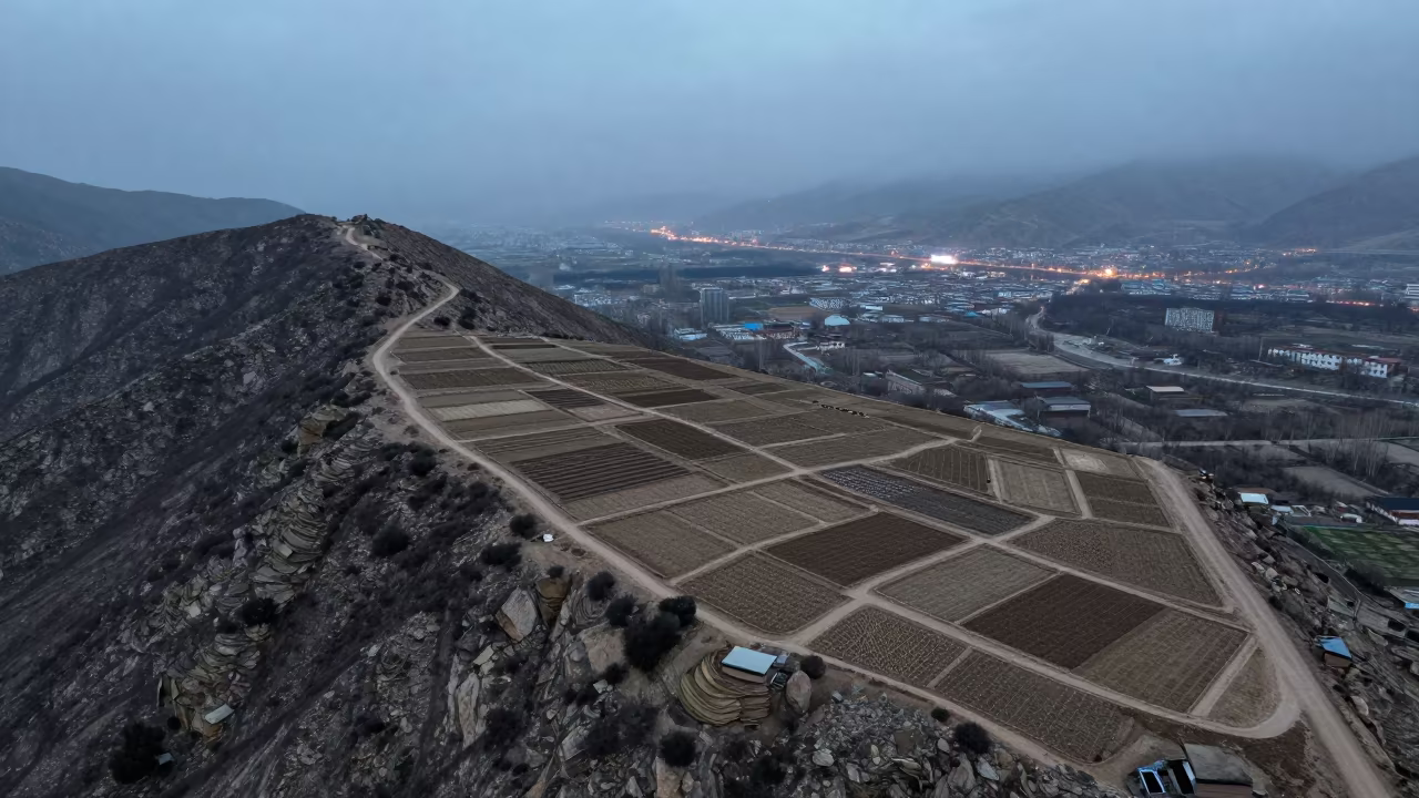 Aerial View of Lhasa Allotments in Steel Blue Mist in at a rocky saddle overlooking a mountain valley near Lhasa