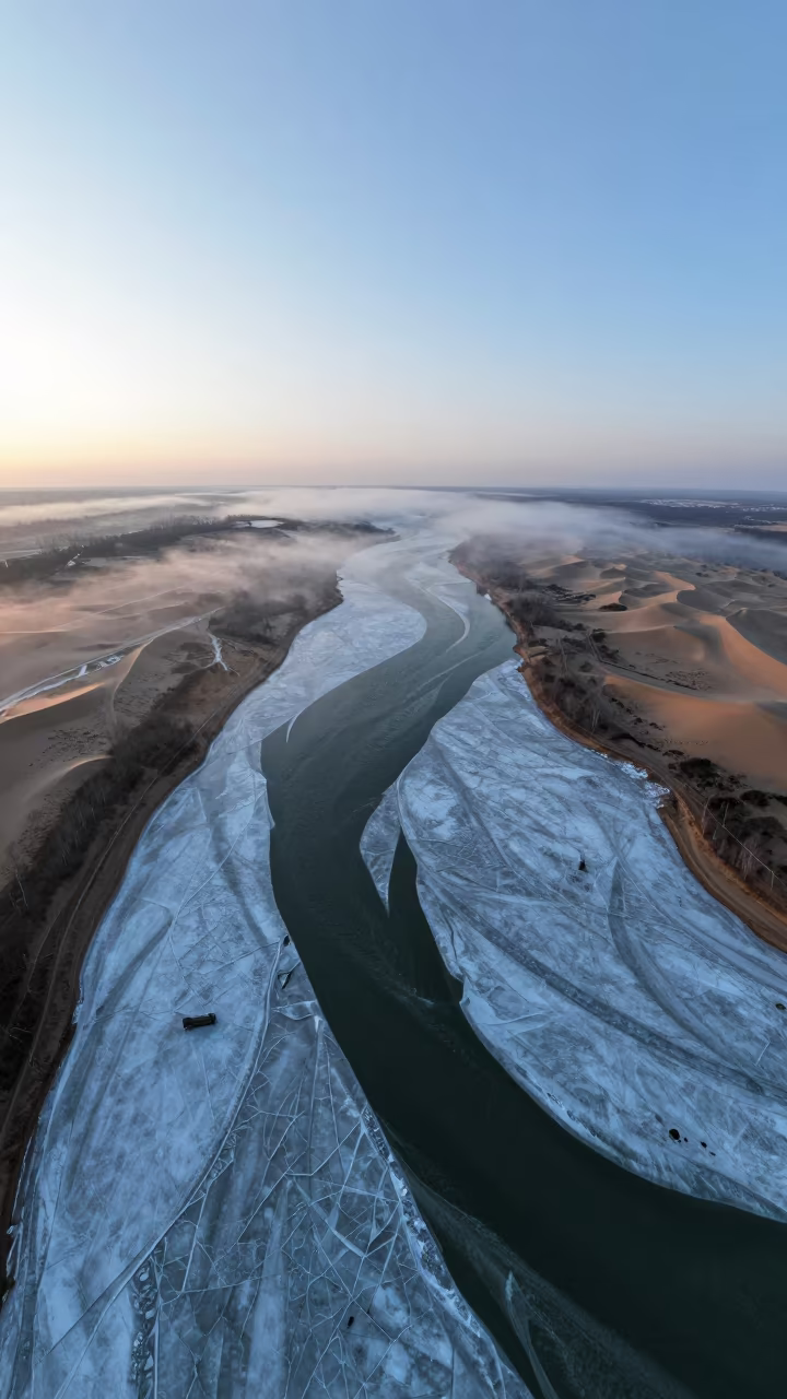 Aerial winter harbor ice thaw blue hour surreal in high above braided river channels in Russia
