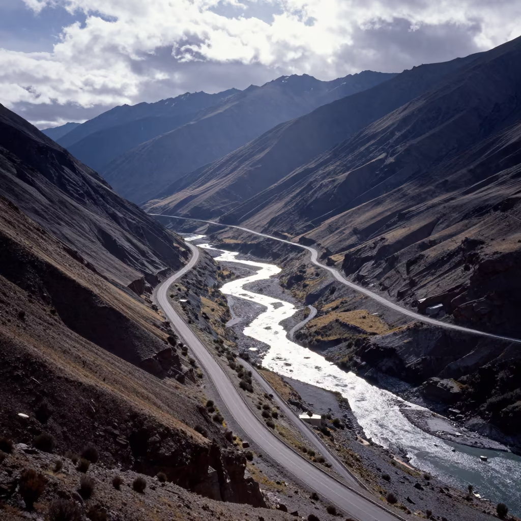 Aerial Winter Road Switchback Over Chilean River in high above braided river channels in Chile