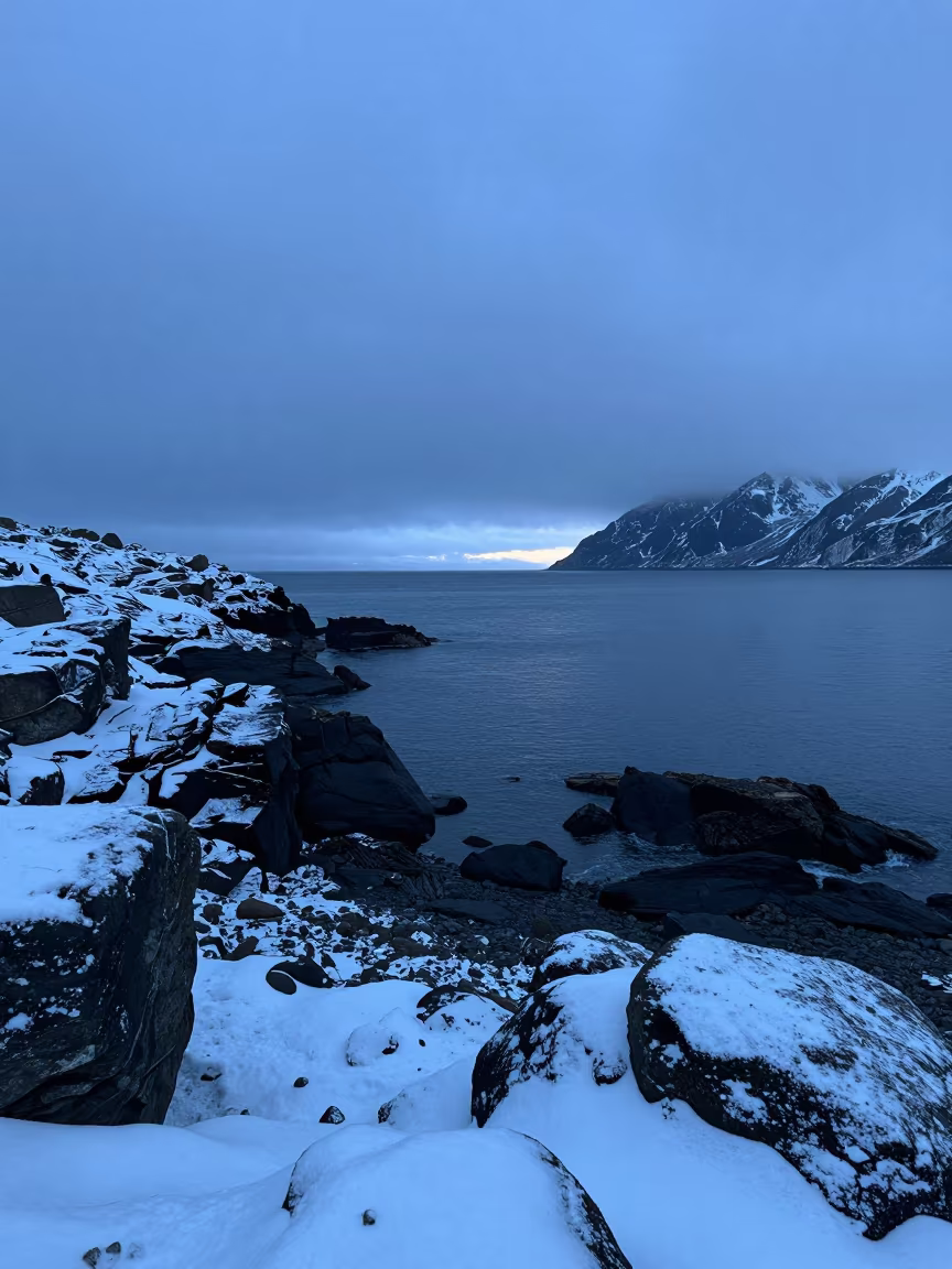 Alaskan Cove in Blue Hour Snow in along a wave-cut shoreline in Alaska