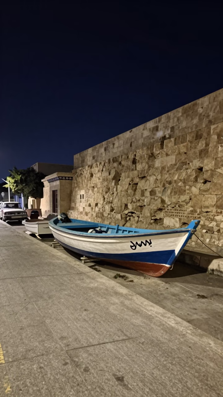 Alexandria Egypt Night Street Scene with Longtail Boat and Concrete Apartment Blocks in in Alexandria, Egypt