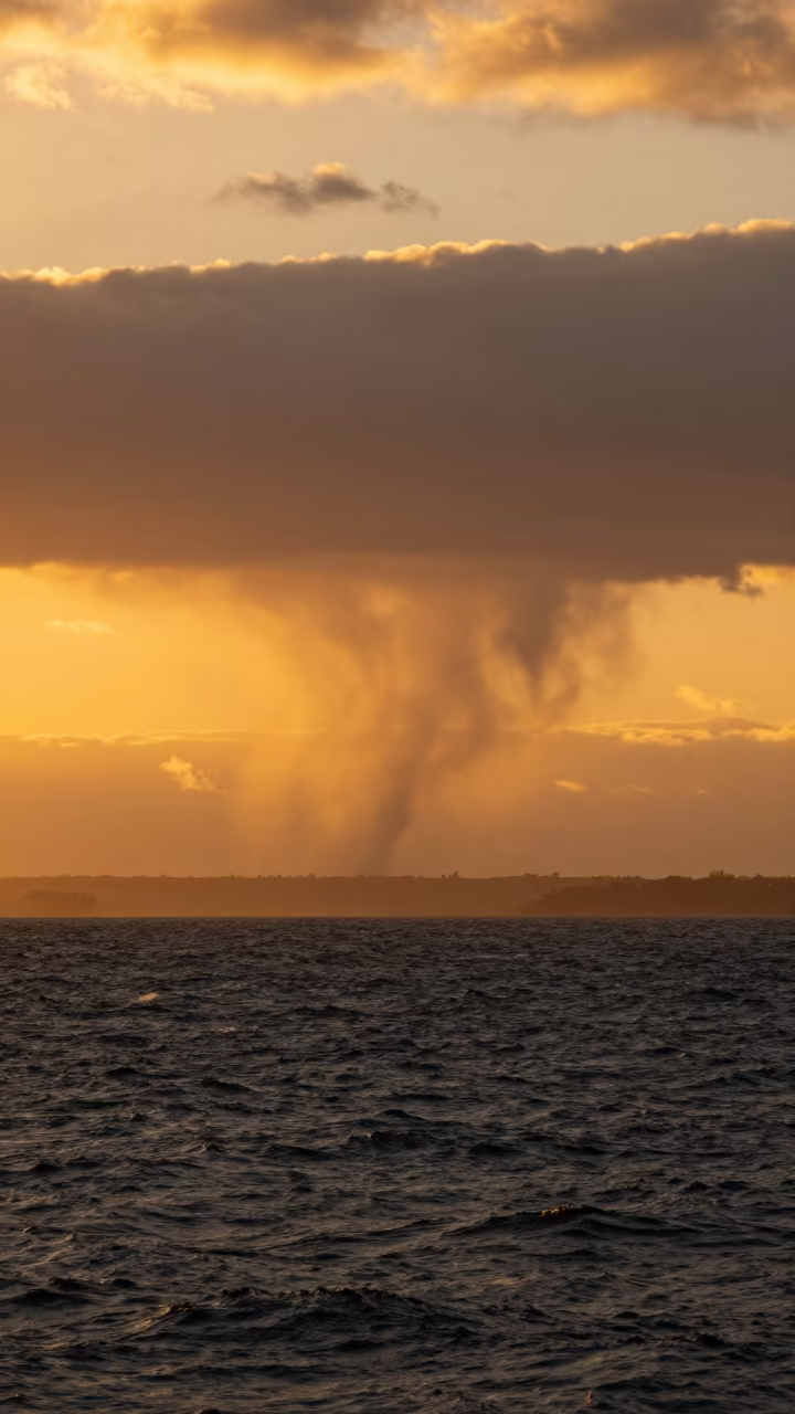 Amber Sunset Waterspout Over Devonport Ocean in across a storm-bright plain near Devonport, Auckland