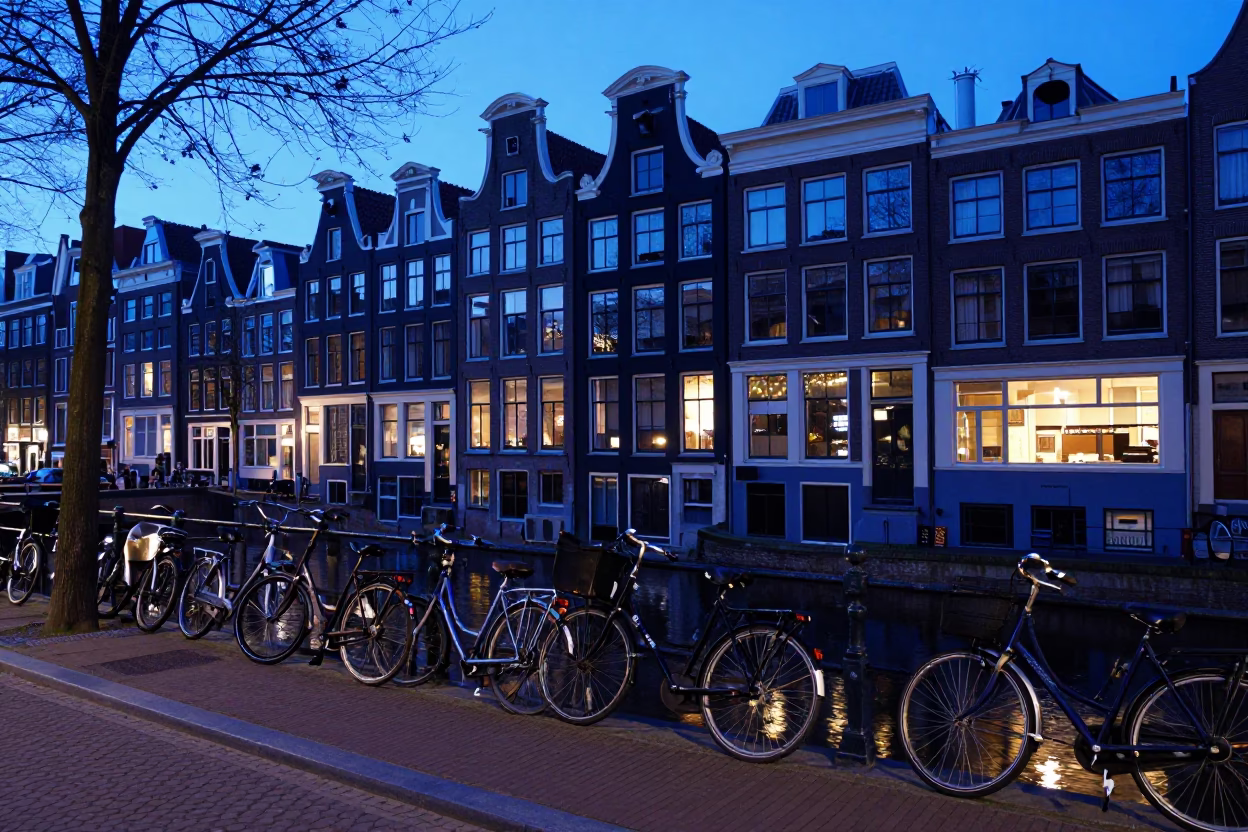 Amsterdam canal house evening blue light street scene with bicycles and pedestrians in in Amsterdam, Netherlands