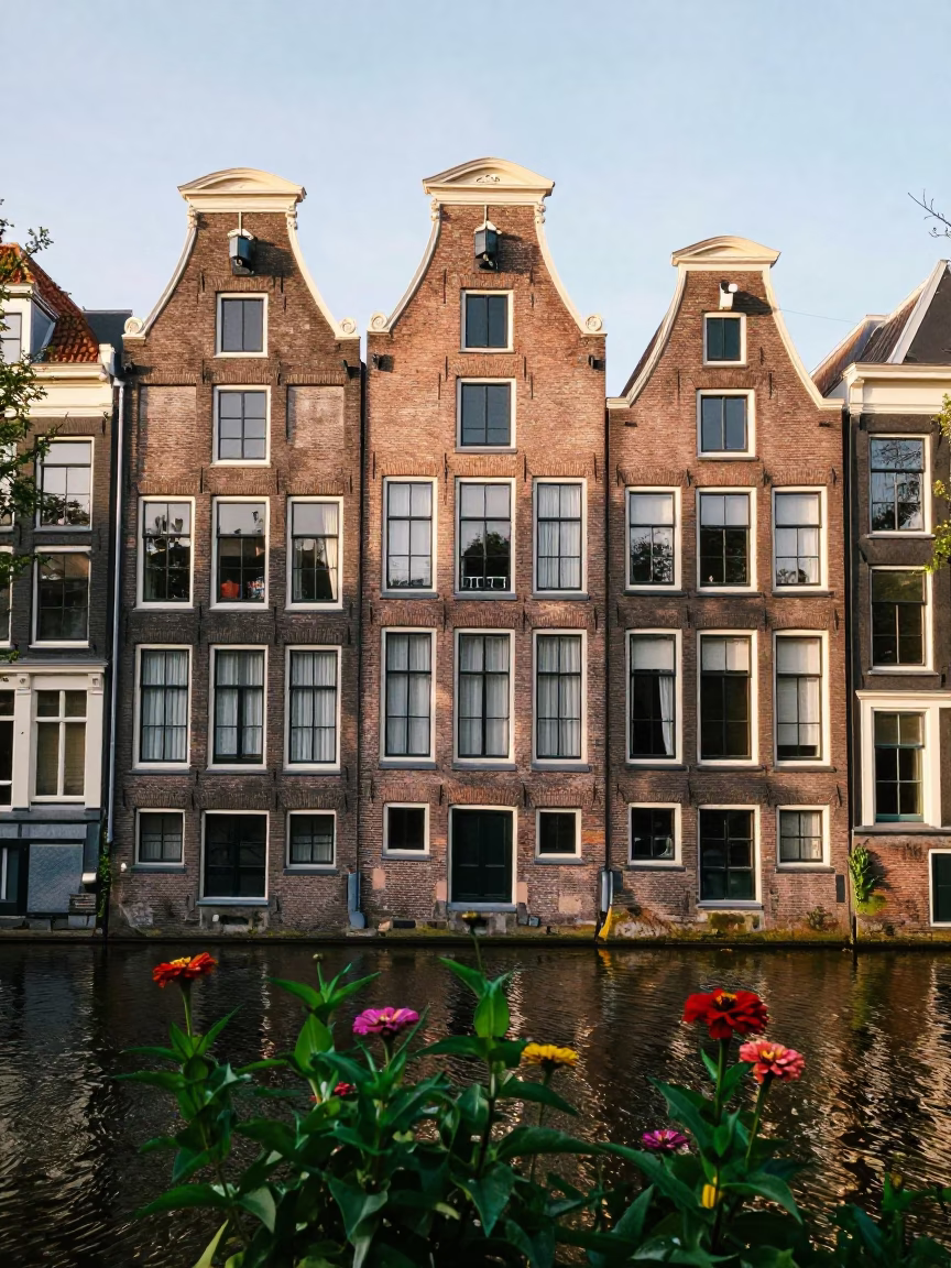 Amsterdam Canal House Facade and Zinnias in Early Afternoon Sunlight in in Amsterdam, Netherlands