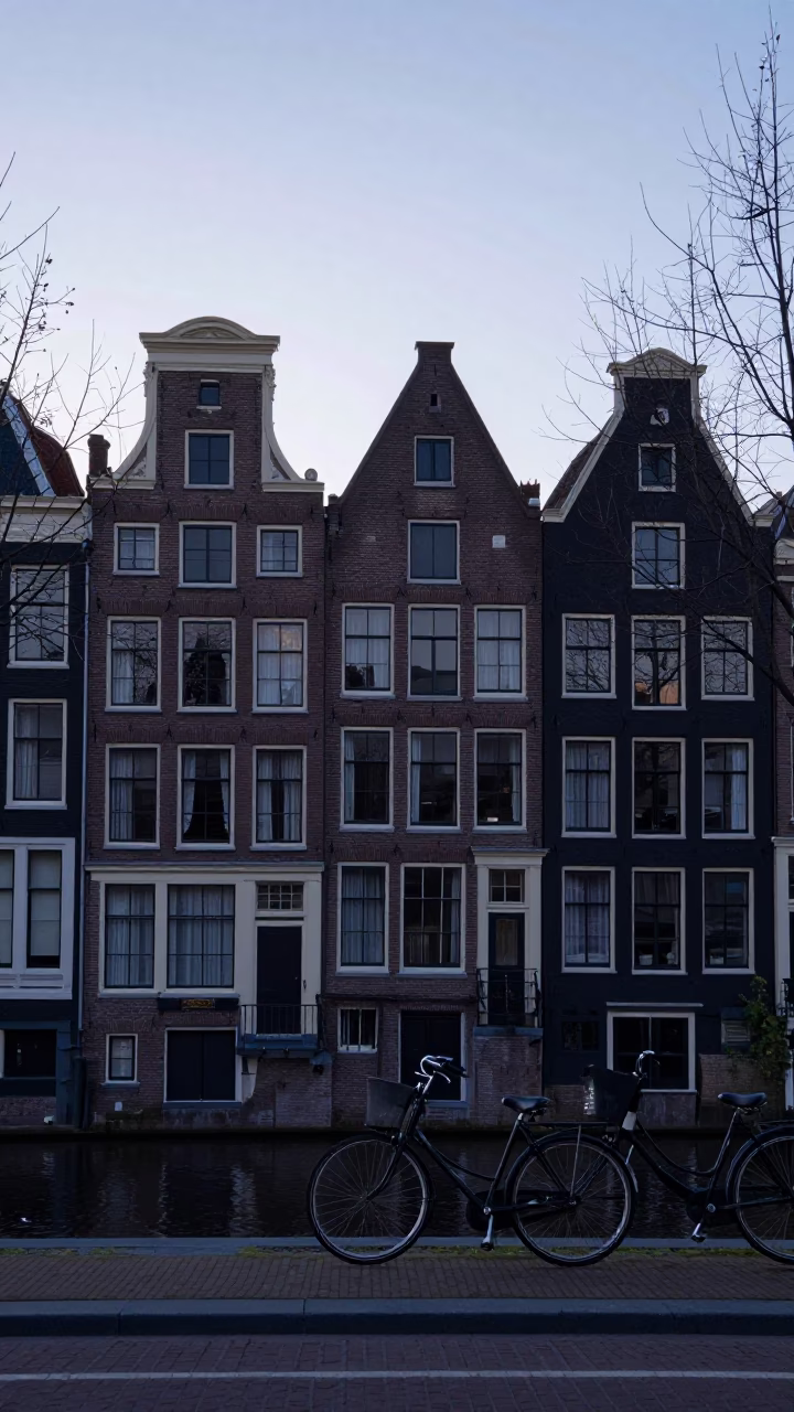 Amsterdam Canal House Facade at Dawn with Bicycle and Wet Cobblestones in in Amsterdam, Netherlands