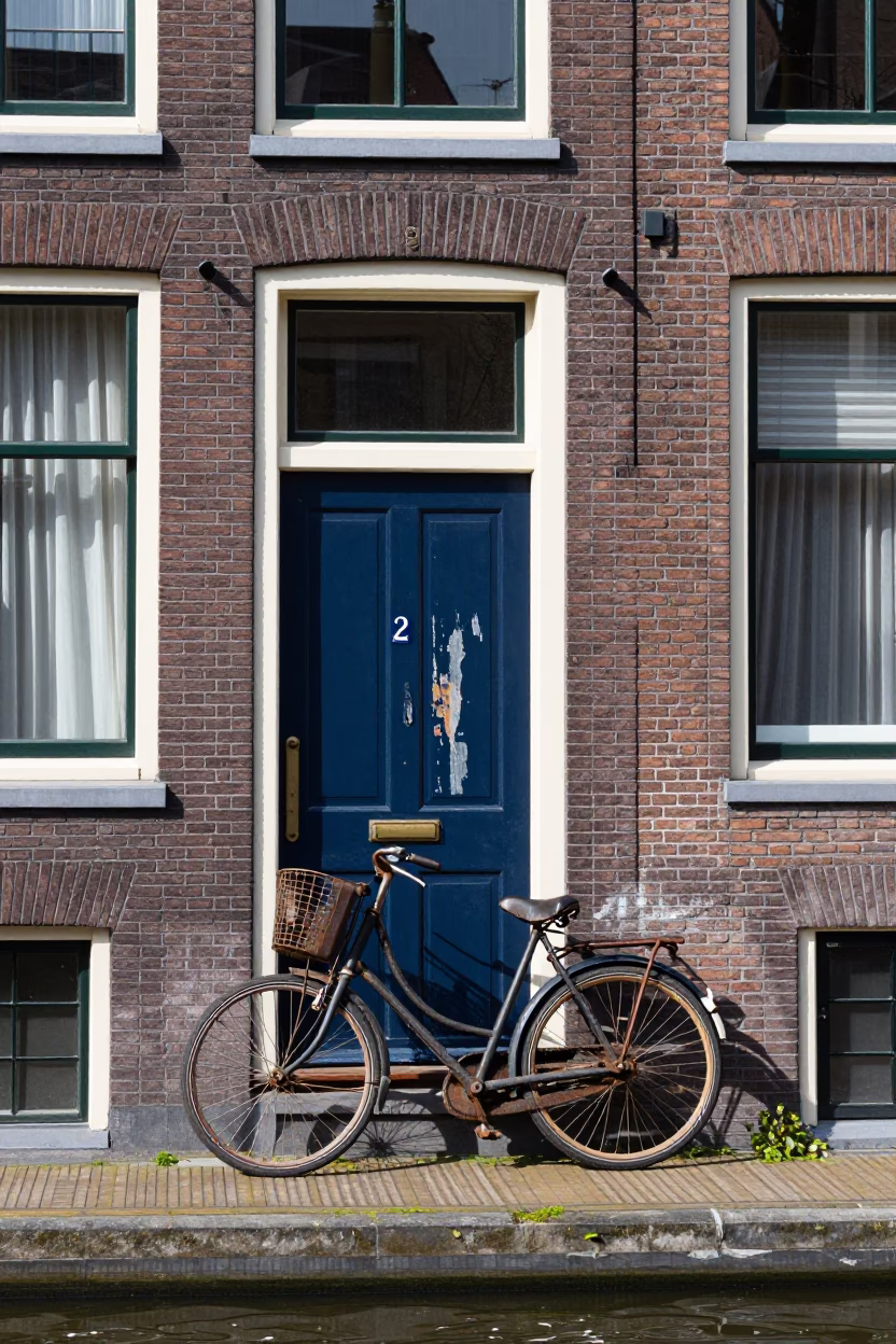 Amsterdam Canal House Facade Detail with Vintage Bicycle and Brickwork in Midmorning Light in in Amsterdam, Netherlands