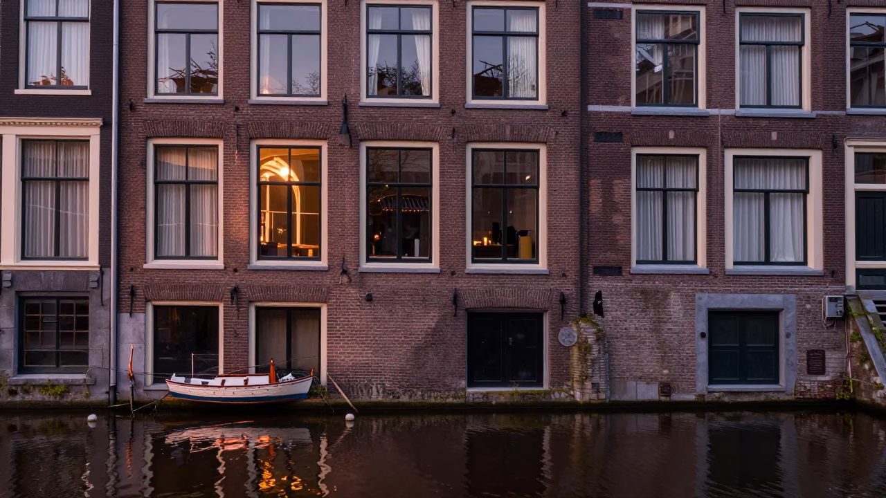 Amsterdam canal house facade in copper dusk light with model ship display in in Amsterdam, Netherlands