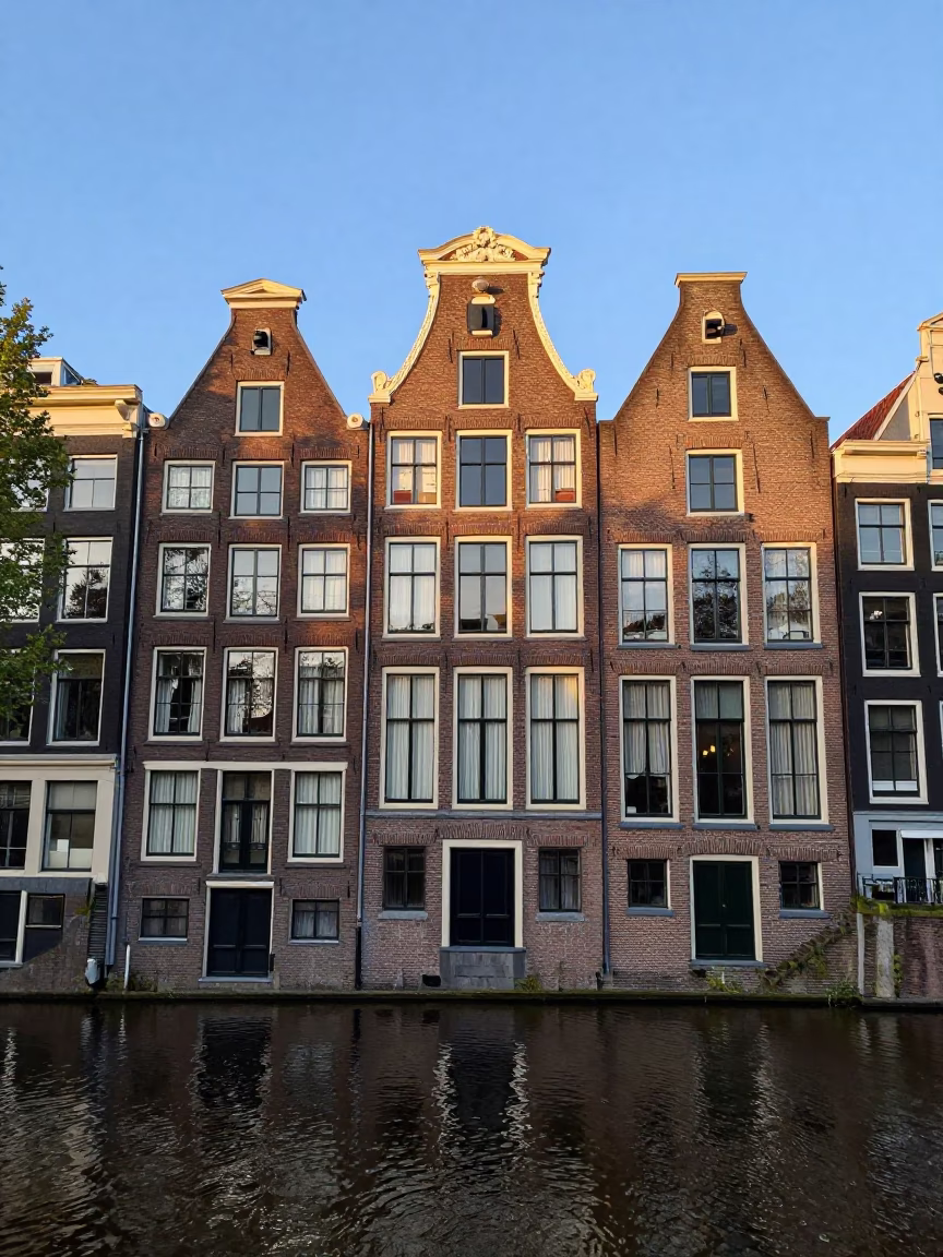 Amsterdam Canal House Facade in Late Afternoon Light with Stacked Plates and Street Life in in Amsterdam, Netherlands
