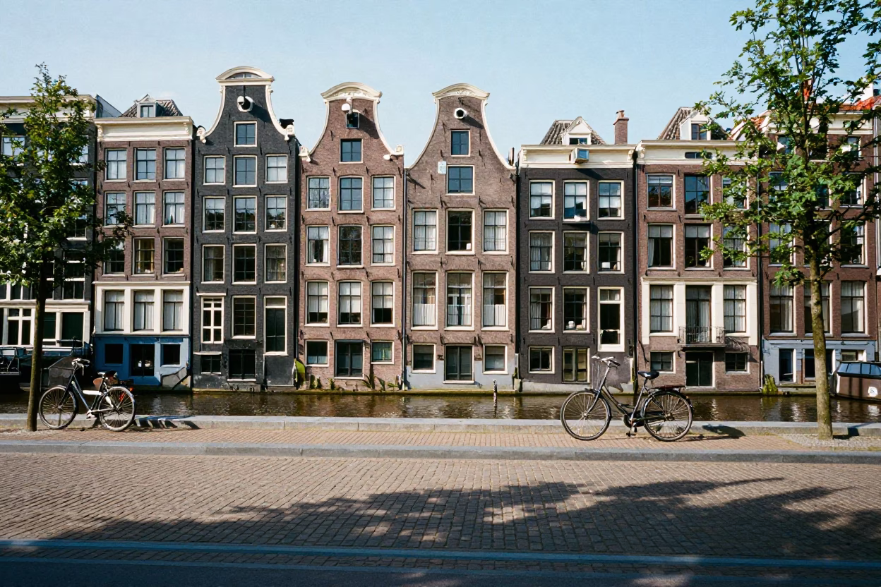 Amsterdam Canal House Facade with Bicycle and Cobblestone Street Midday in in Amsterdam, Netherlands
