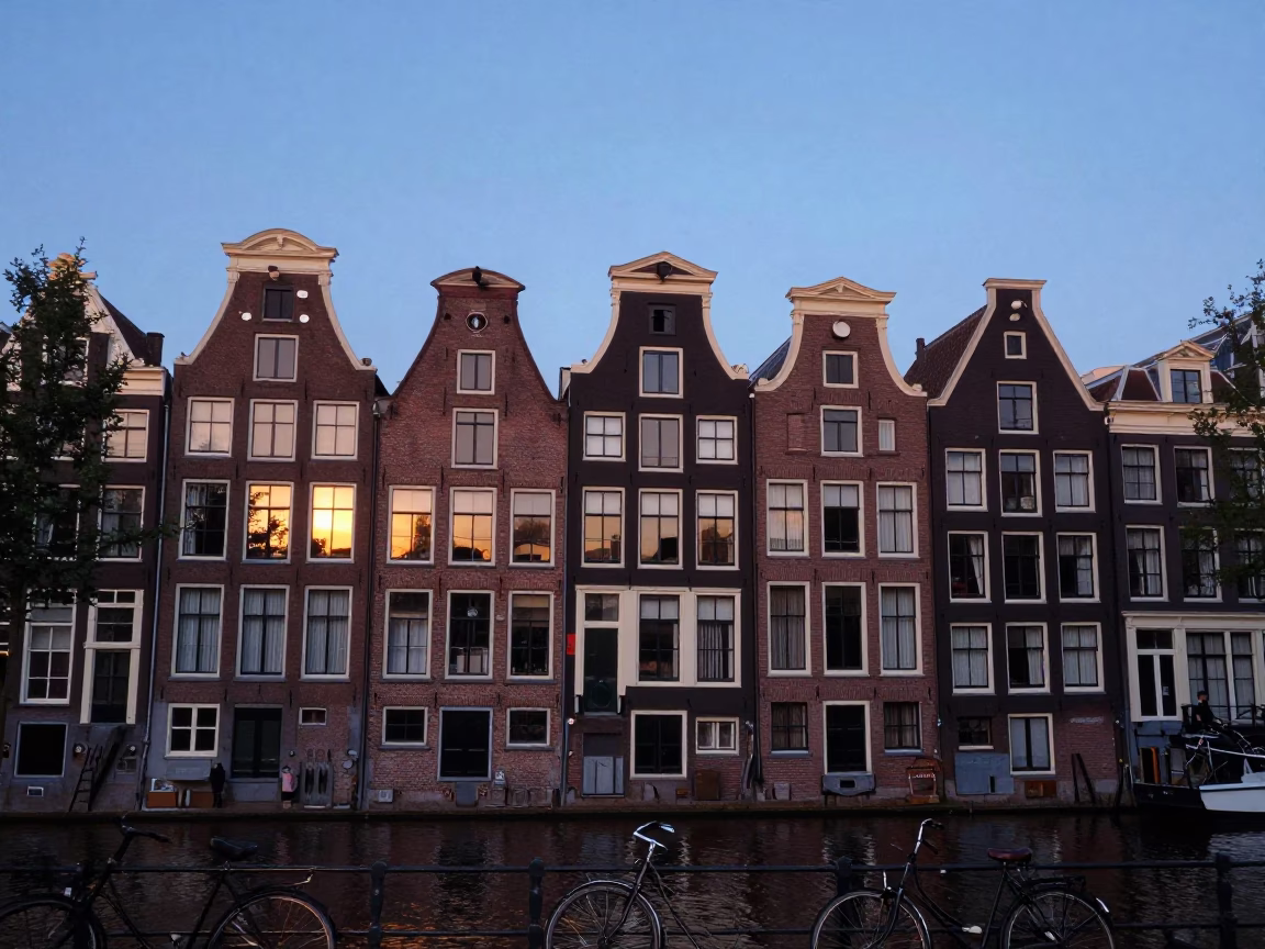 Amsterdam Canal House Facade with Bicycle and Evening Sky in in Amsterdam, Netherlands