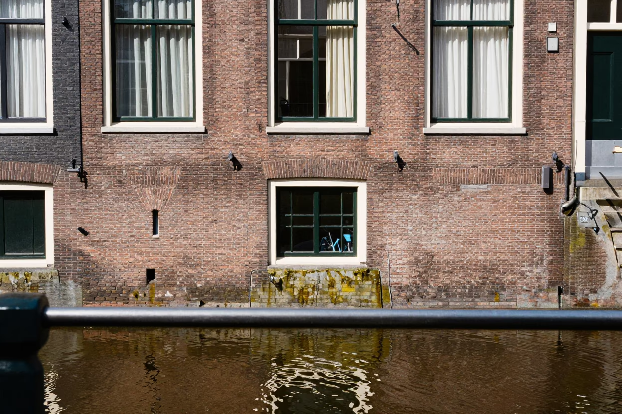 Amsterdam Canal House Facade with Shallow Reflection on Brushed Steel at Midday in in Amsterdam, Netherlands