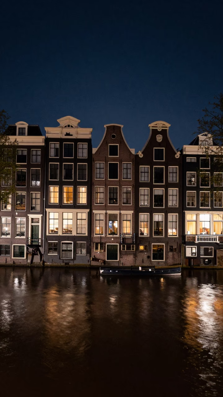 Amsterdam Canal House Night Scene with Traditional Dutch Architecture and Street Reflections in in Amsterdam, Netherlands