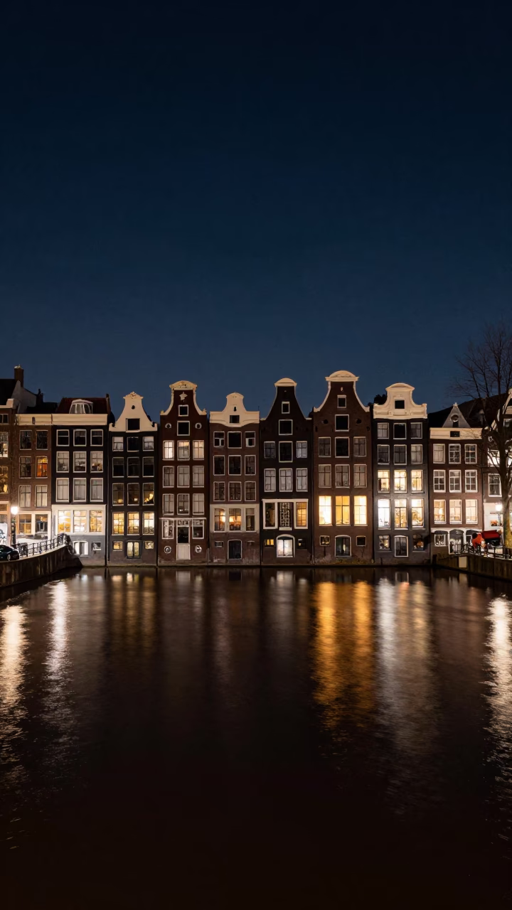 Amsterdam Canal Houses Under Deep Night Sky with Hurry Lane Lamp Reflections in in Amsterdam, Netherlands