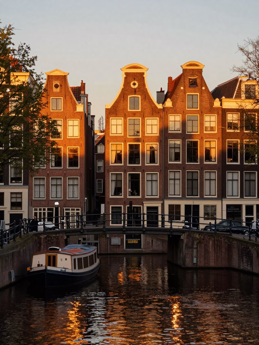 Amsterdam Canal Sunset with Brick Architecture and Traditional Dutch Boats in in Amsterdam, Netherlands