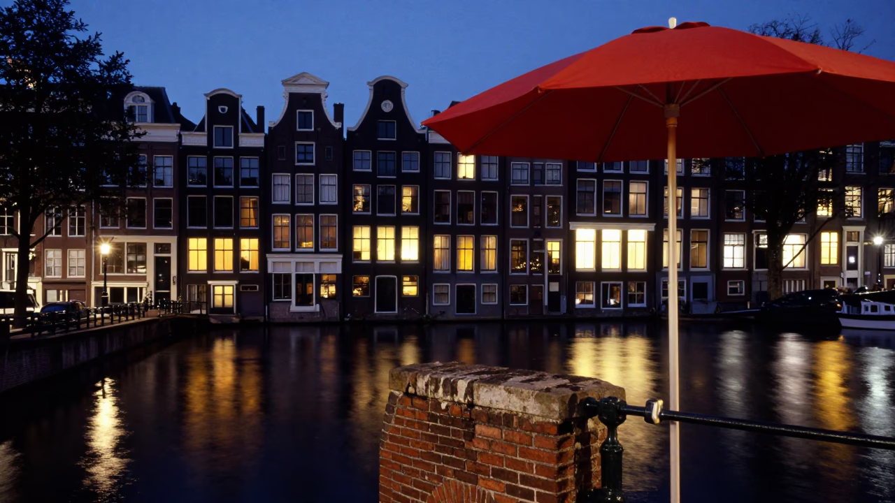 Amsterdam Canal Twilight Scene with Red Umbrella Stand and Tea Tin on Brick Balcony in in Amsterdam, Netherlands