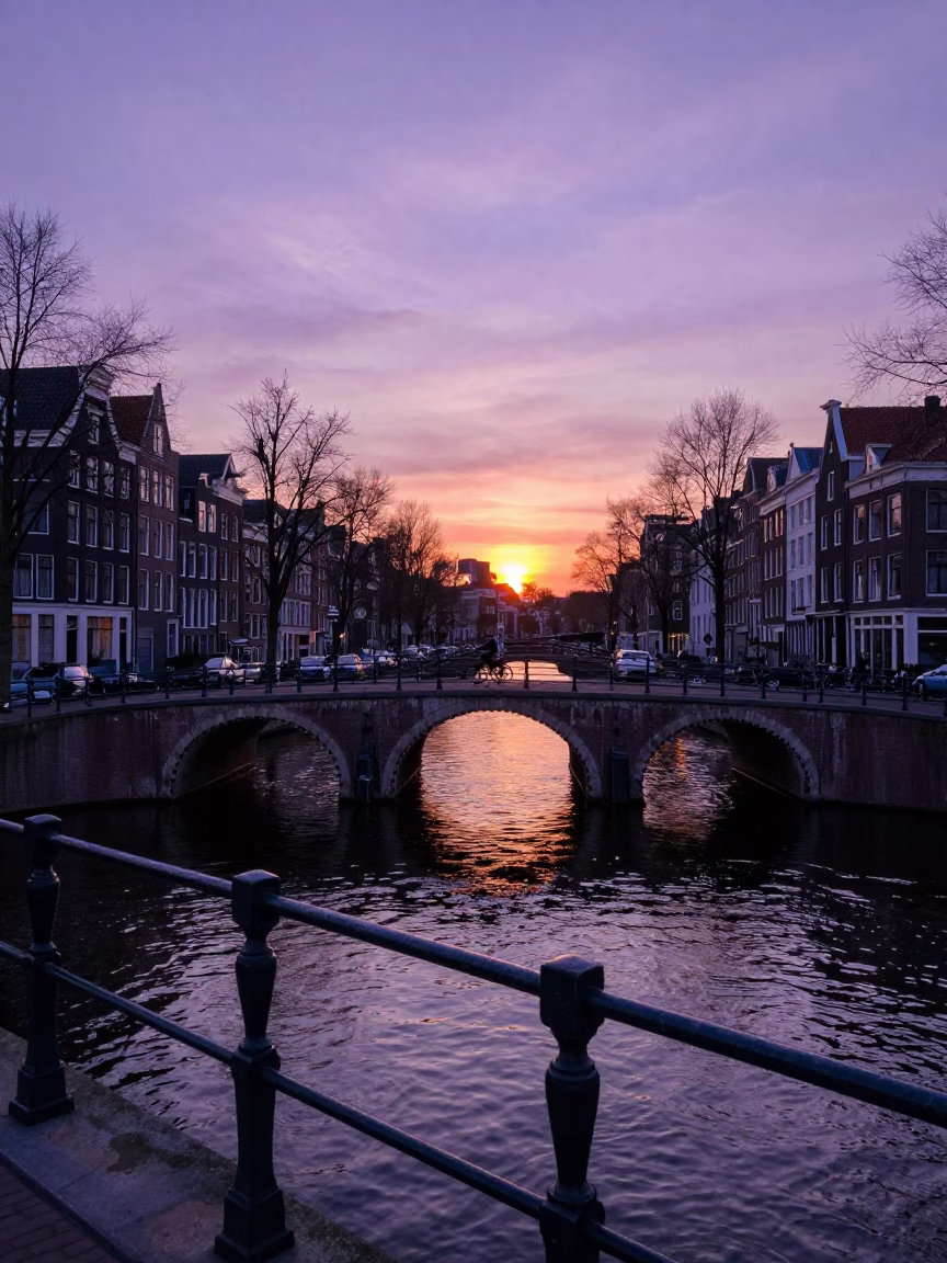 Amsterdam Evening Sunset Over Canal Bridge With Cyclist And Violet Sky in in Amsterdam, Netherlands
