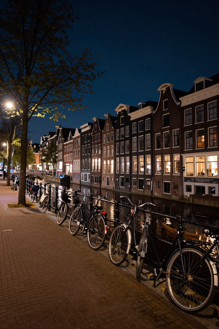 Amsterdam Night Canal Street with Bicycles and Cobblestones Under Dark Sky in in Amsterdam, Netherlands
