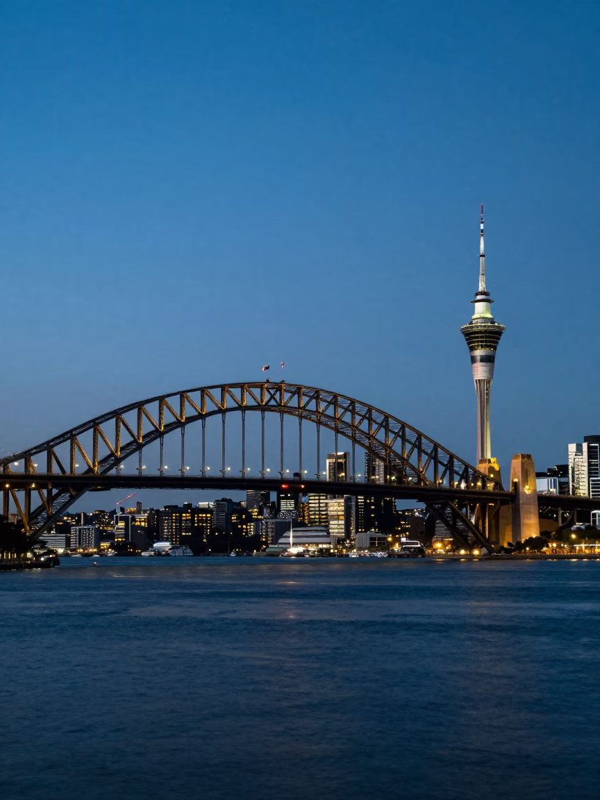 Auckland Harbour Bridge and Sky Tower illuminated during blue hour evening twilight in in Auckland, New Zealand