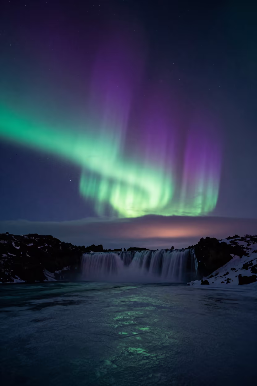 Aurora Over Frozen Waterfall in Iceland Summer Night in from a quiet alpine saddle in Iceland