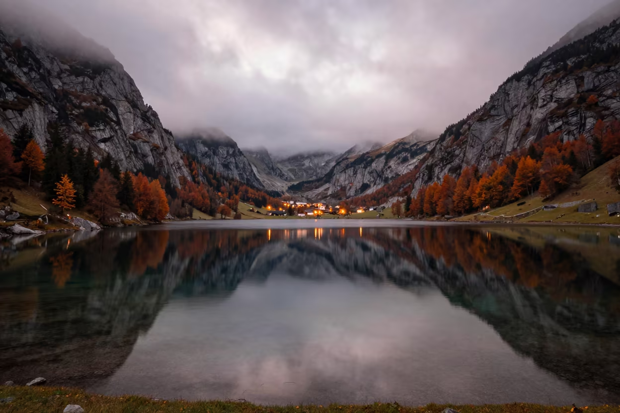 Autumn Cirque Lake Tyrol with Town Glow in along a wave-cut shoreline in Tyrol