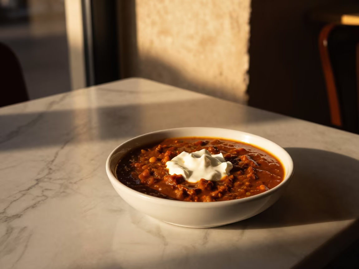 Autumn Goulash Bowl with Sour Cream on Marble Table in on a marble cafe table in Beirut