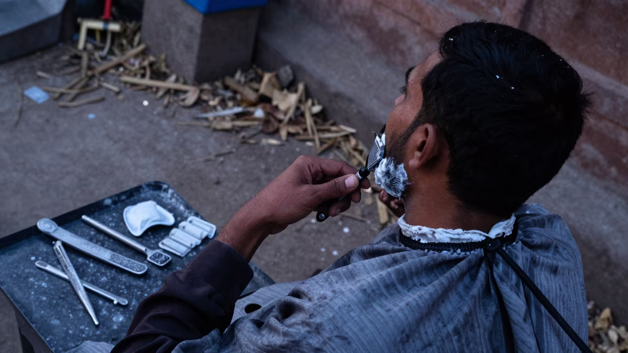 Barber Shaves Client in Indigo Evening Light in near Faizabad