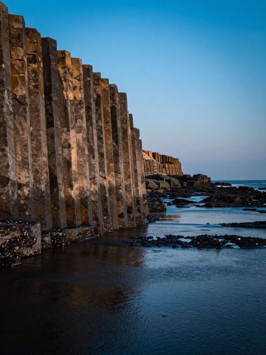 Basalt Columns Silhouetted Against Blue Evening Sky in across a floodplain after rain near Seomyeon, Busan