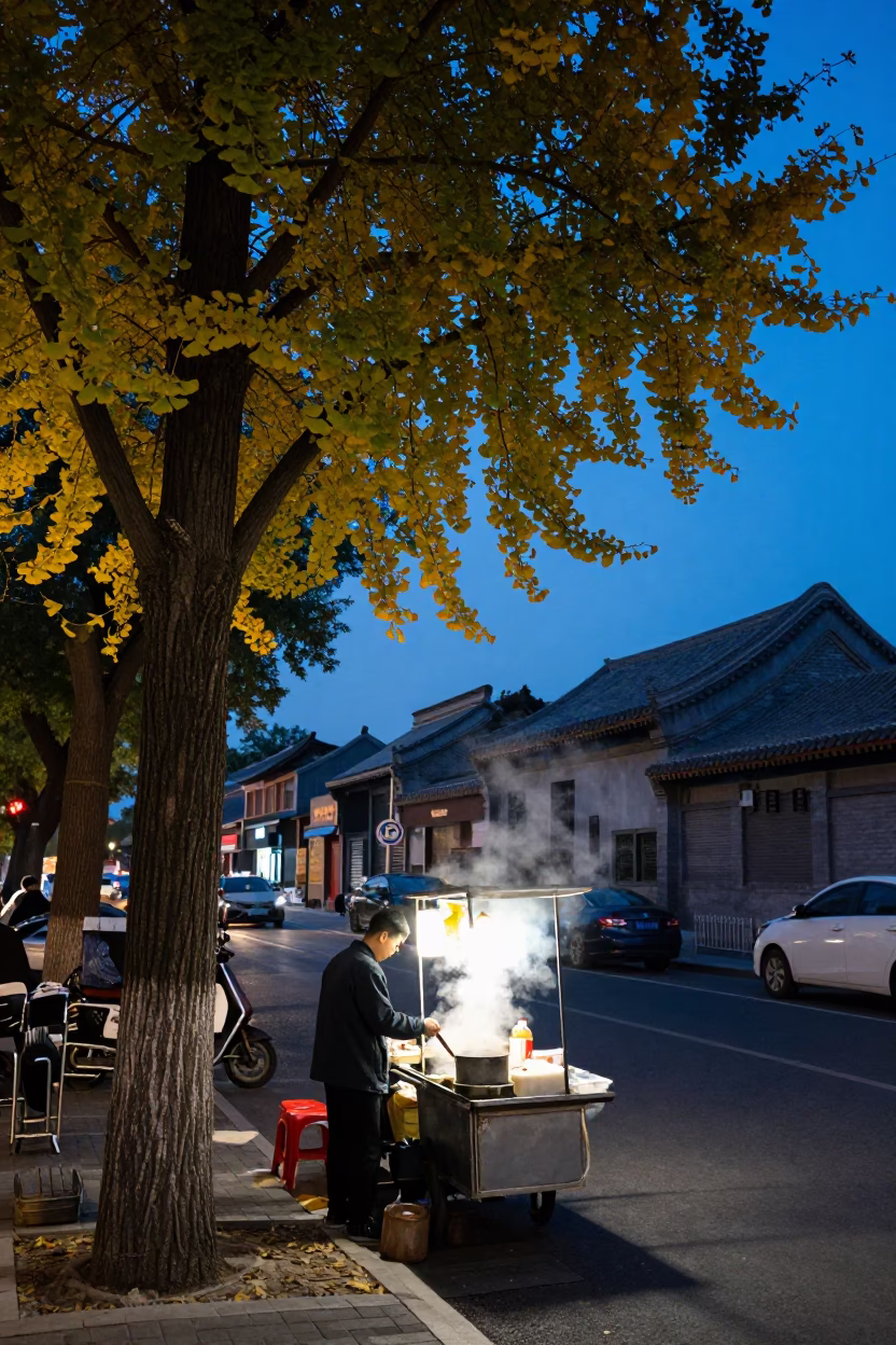 Beijing indigo twilight street scene with ginkgo tree and street food vendor in in Beijing, China