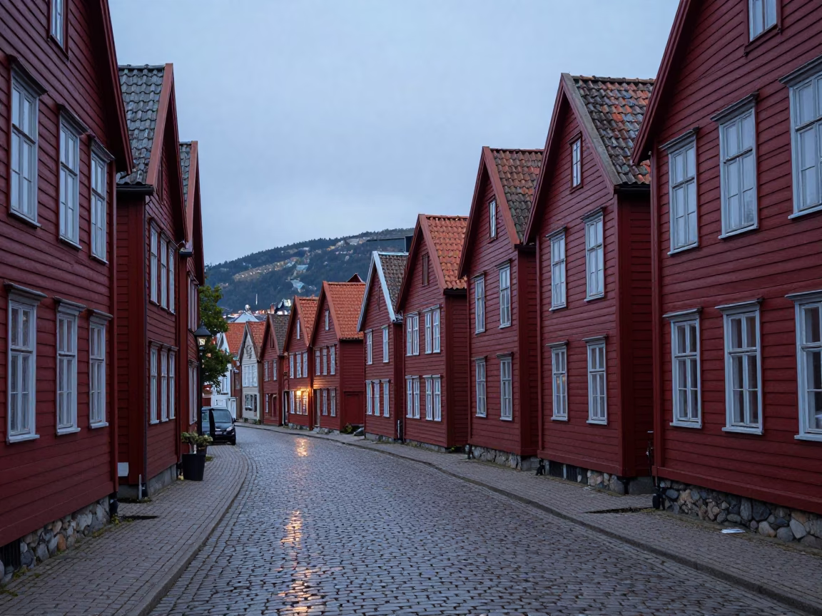 Bergen Norway Before Dawn Cobblestone Street with Red Rorbu Houses and Wet Pavement Reflections in in Bergen, Norway