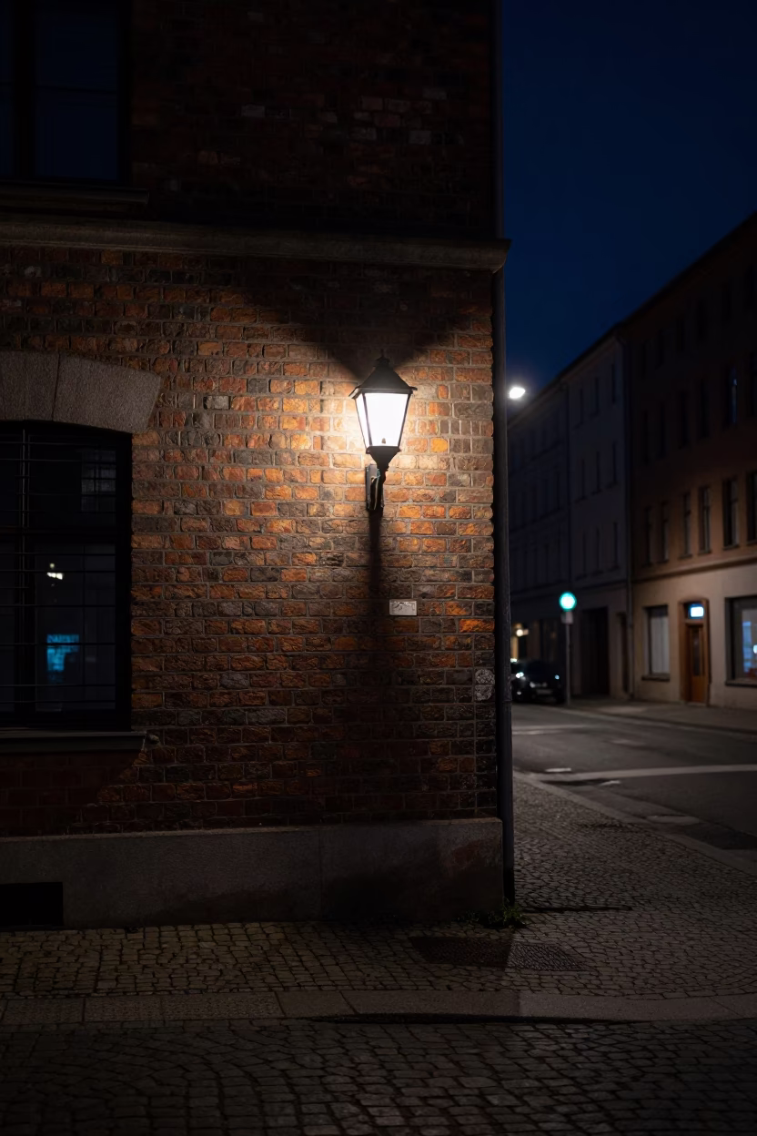 Berlin Night Street Scene with Wall Sconce Illuminating Cobblestones and Urban Architecture in in Berlin, Germany