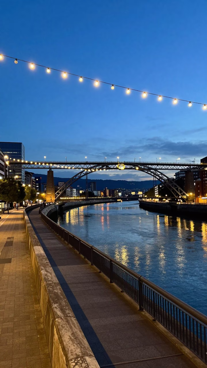 Bilbao Spain Blue Hour Street Scene with String Lights and Bridge Reflections in in Bilbao, Spain