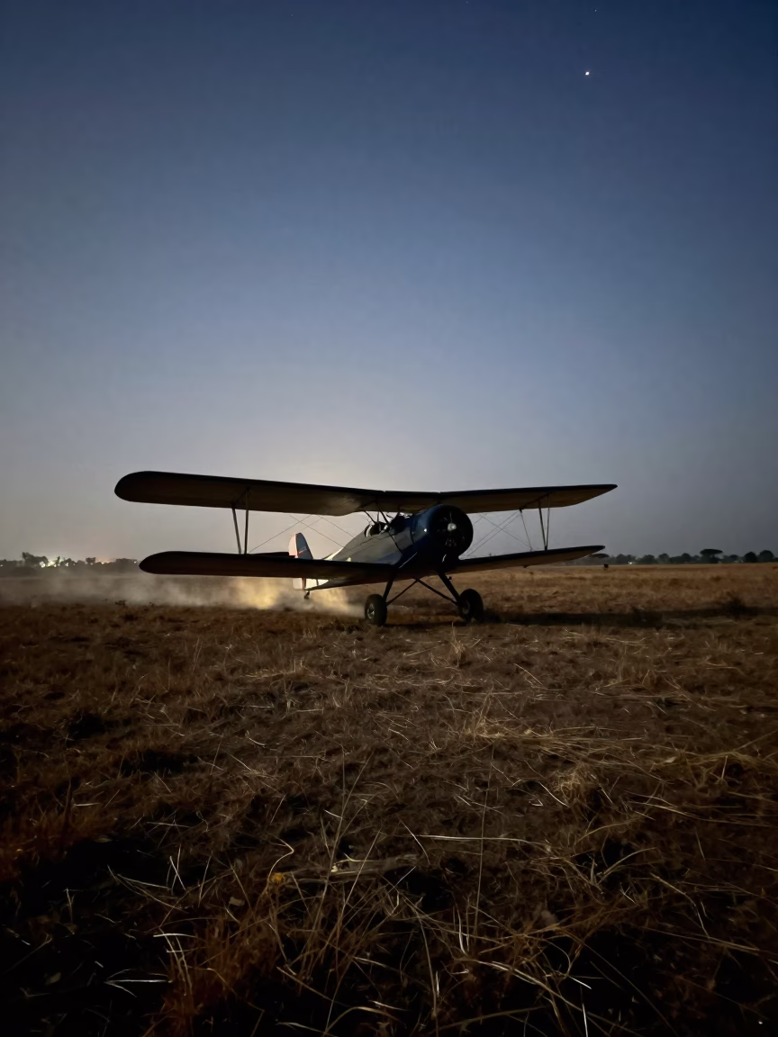 Biplane Flying Low Over Tanzanian Field in on a wind-open causeway in Tanzania