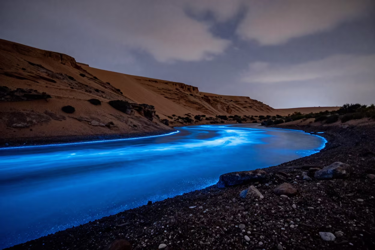 Blue Bioluminescent Bay Under Desert Escarpment in beneath a wind-cut desert escarpment near Luena
