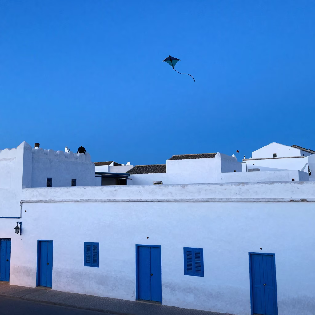 Blue Hour in Essaouira with Kites Flying Over White Walls and Blue Doors in in Essaouira, Morocco