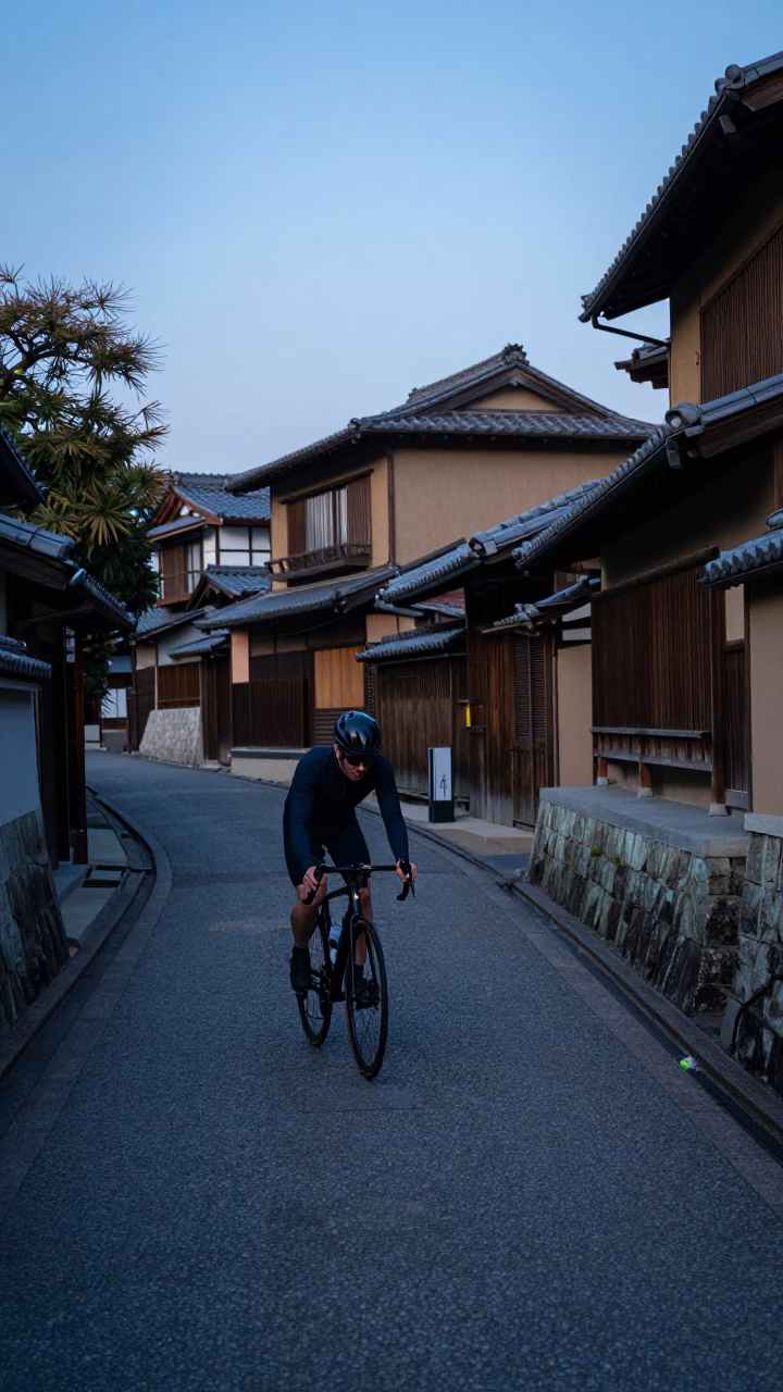 Blue Hour Kyoto Street Scene with Cyclist Climbing Switchback Near Traditional Architecture in in Kyoto, Japan