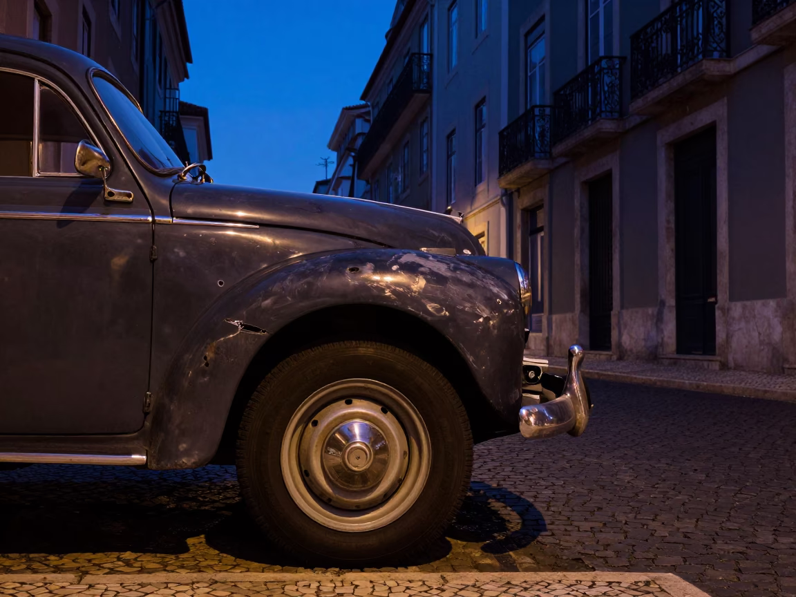 Blue Hour Street Scene in Lisbon Portugal with Vintage Car and Dented Metal Rim in in Lisbon, Portugal