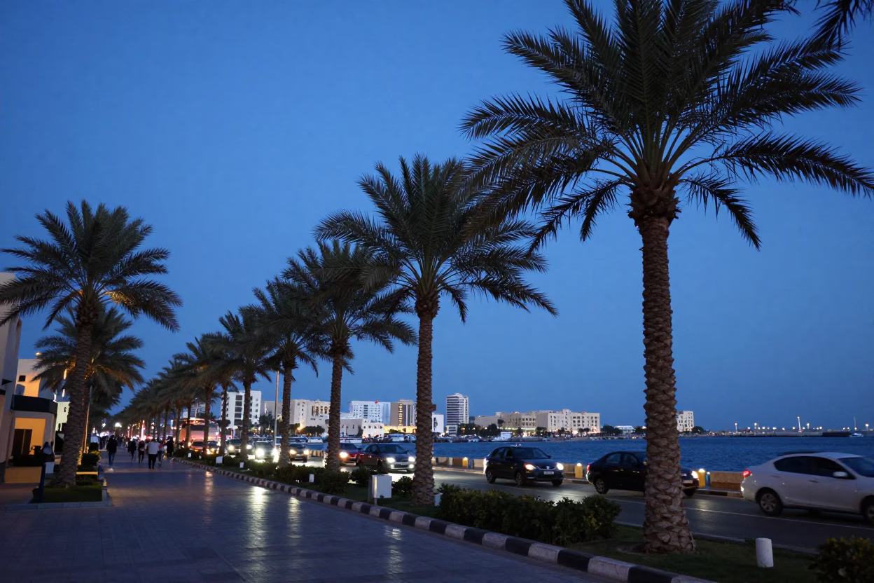 Blue Hour Street Scene in Muscat Oman with Palm Trees and Busy Harbor Activity in in Muscat, Oman