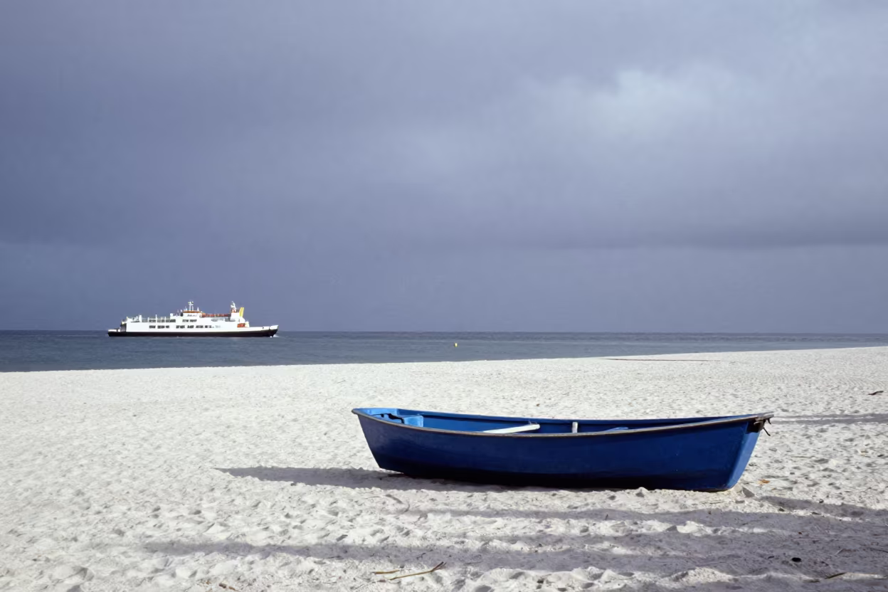 Blue Rowboat on White Sand Before Sunrise in across a remote ferry crossing in Ecuador