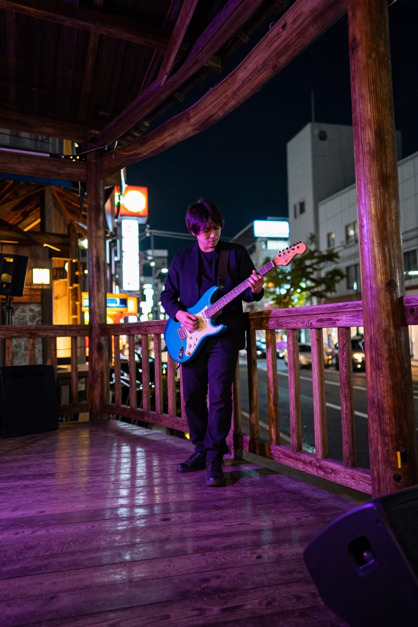Blues Guitarist on Neon Tokyo Porch Night in on a theater stage in Harajuku, Tokyo
