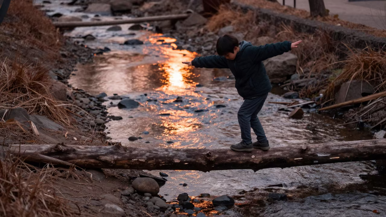 Boy Balances on Log Over Creek in Osaka in in Osaka