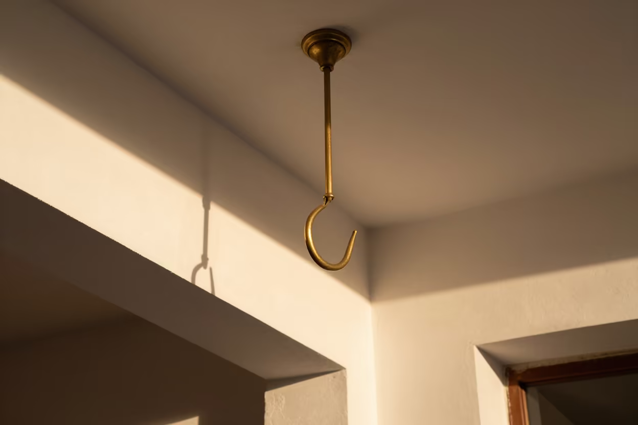 Brass Hook Shadow on Plaster Skylight in inside a skylit passageway in Bogyoke Market, Yangon