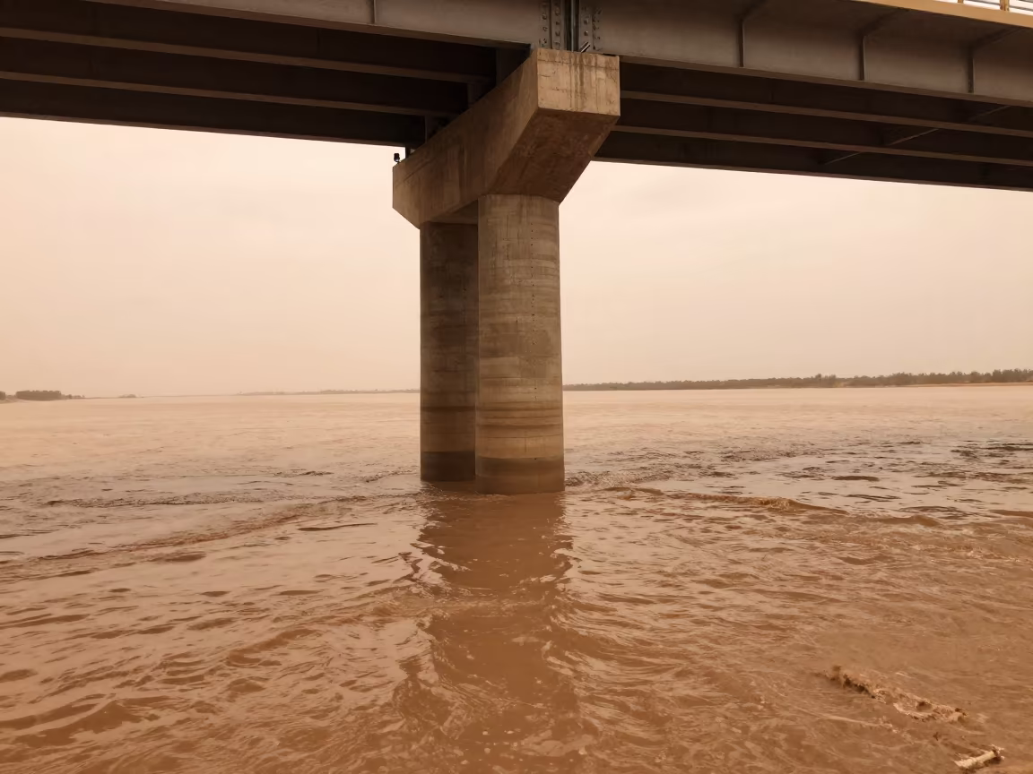 Bridge Pier Cutwater Splits Flood Brown Current in beneath a bridge span in the Gobi Desert
