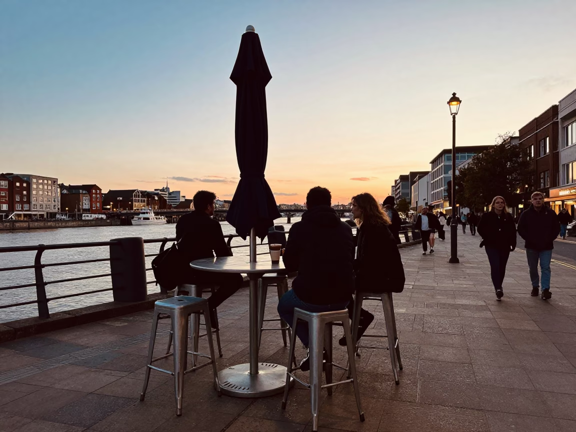 Bristol quayside evening scene with metal stools and umbrellas in in Bristol, United Kingdom