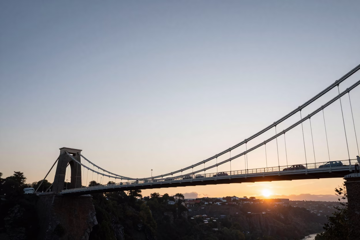 Bristol Suspension Bridge at Sunset with Vintage Cars and Wet Cobblestone Streets in in Bristol, United Kingdom