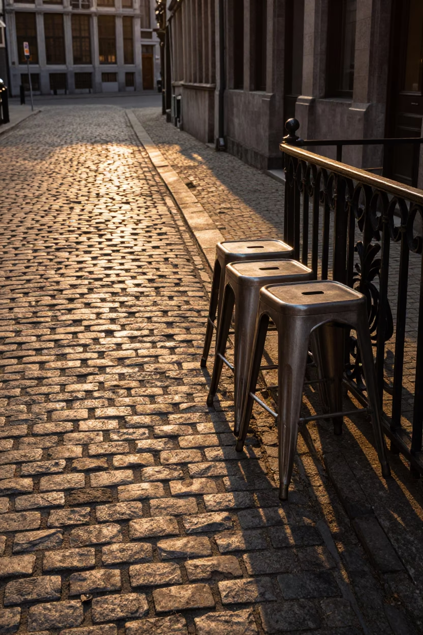 Brussels Evening Light on Cobblestone Street with Metal Stools and Porcelain Jars in in Brussels, Belgium