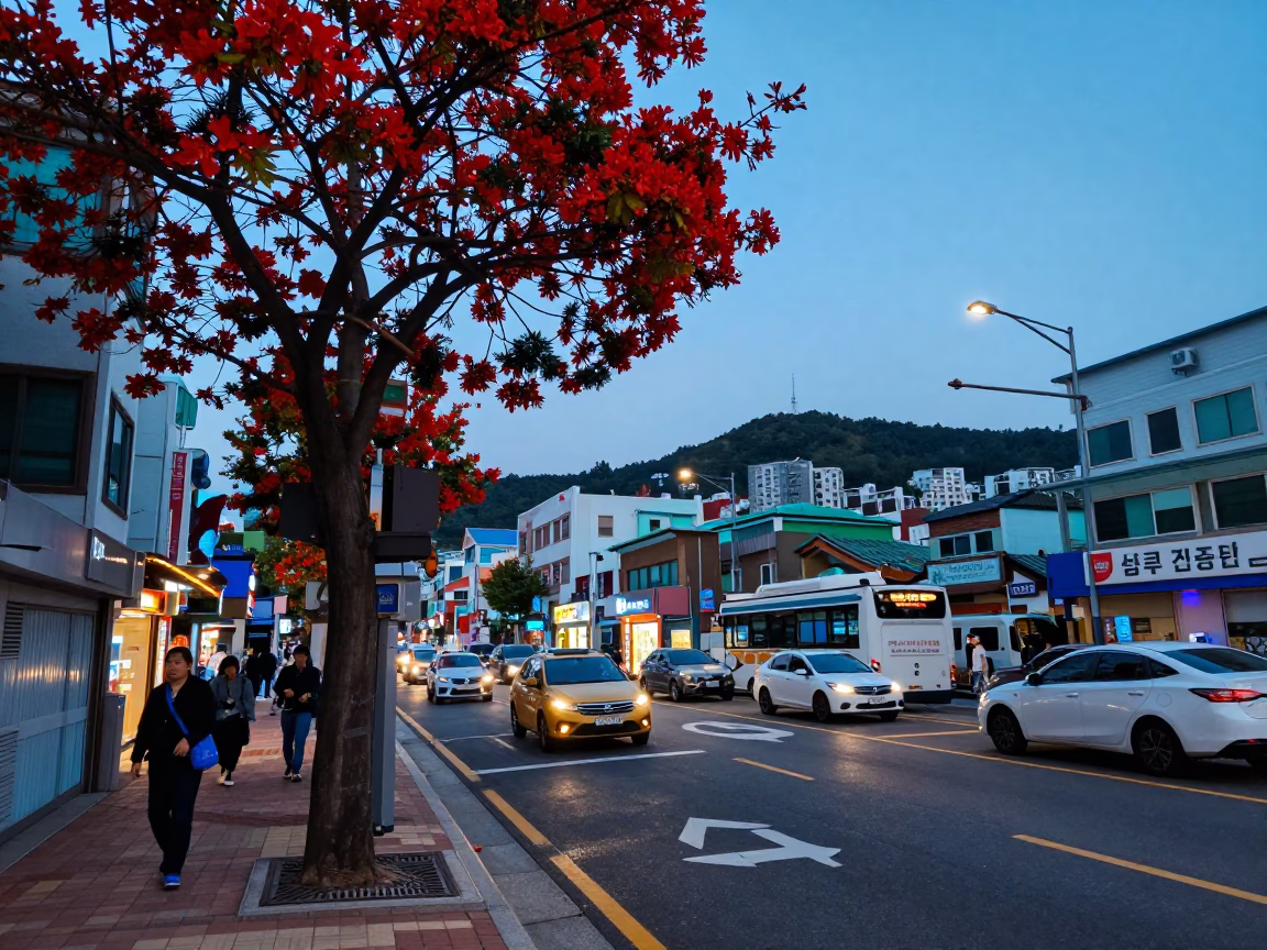 Busan Evening Street Scene with Red Flame Trees and Glowing Cafe Windows in in Busan, South Korea